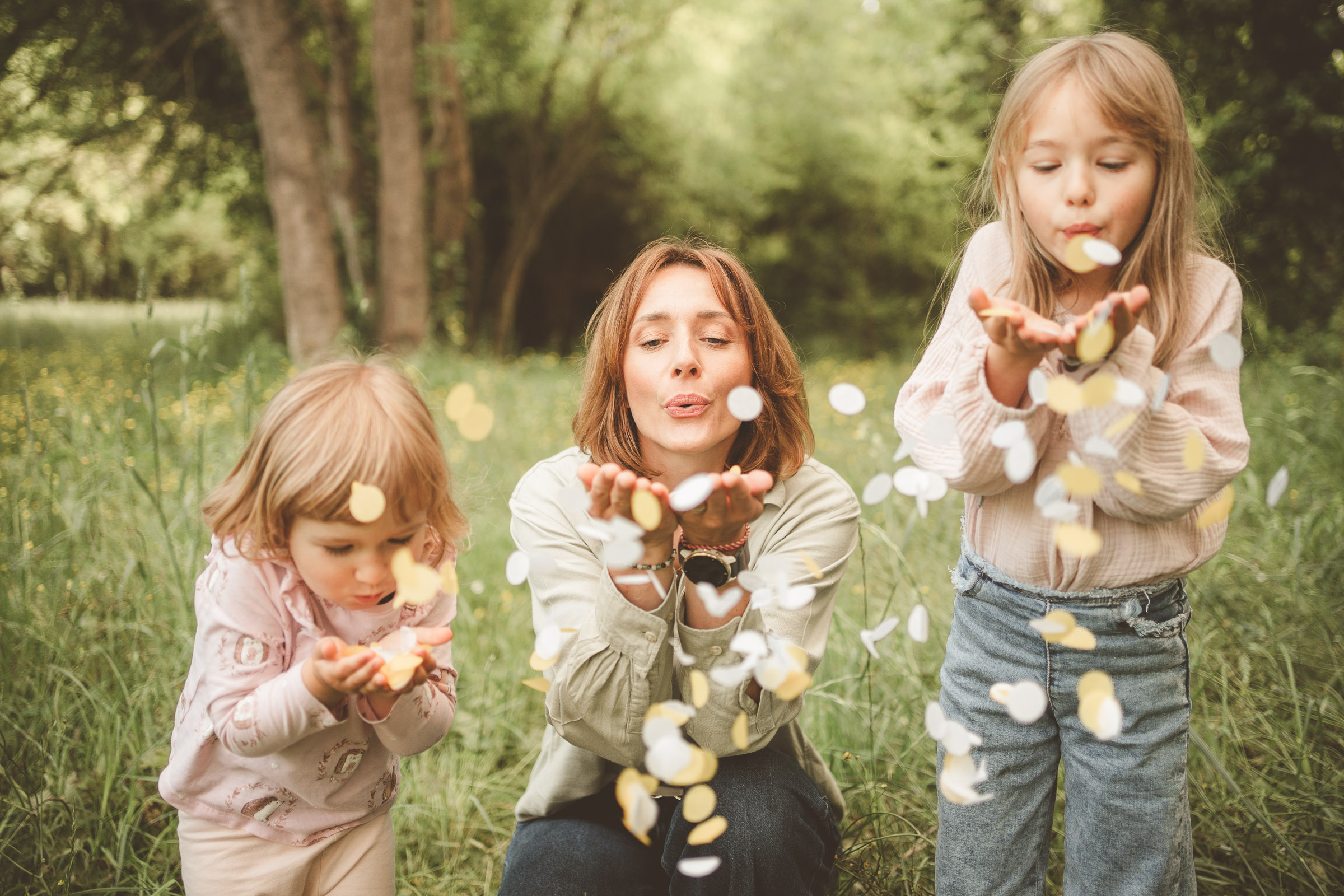 Uśmiechnięta mama z dziećmi podczas plenerowej sesji rodzinnej na Śląsku. Naturalna fotografia rodzinna wykonana w Żorach, przedstawiająca czułość i radosną zabawę na łonie natury.
